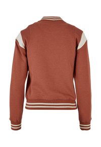 Bomberska jakna rjave-rjave barve z belim poudarkom na ramah, z izrazitimi črtastimi rebrastimi manšetami in robom. Gladek tekstura tkanine.