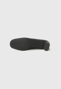 Black leather high-heeled shoe with a smooth upper, rounded toe, and a textured rubber sole for grip, featuring a low block heel.