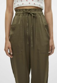 Pantalons olive vert, légers, à taille élastique avec cordon de serrage, dotés de deux poches latérales et d'une coupe ample et décontractée. Tissu texturé.