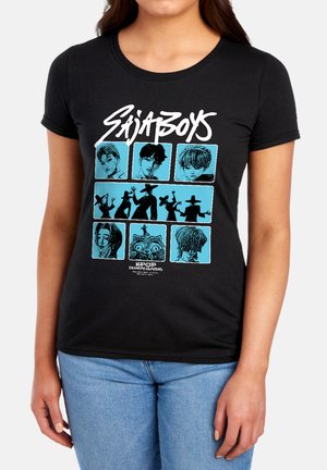 Woman wearing a black t-shirt featuring nine blue panels with stylized faces, silhouettes, and the text "Sajaboys" and "KPOP Demon Hunters."
