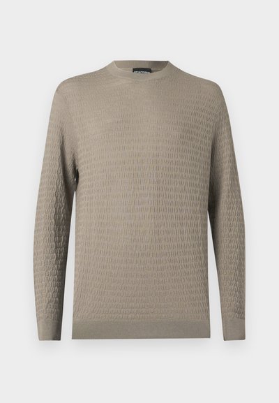 Lys beige genser med et teksturert mønster, rund hals, lange ermer og ribbestrikkede mansjetter og kant. Laget av et mykt materiale.