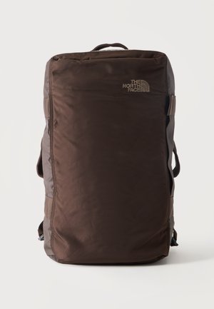 Sac à dos rectangulaire marron foncé avec poignée supérieure et logo "The North Face" à l'avant sur fond blanc.
