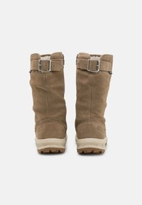 Braune Wildlederschuhe mit Reißverschluss, verstellbarem Riemen und metallischer Schnalle. Weiße Fleece-Innensohle und strukturierte beige Gummisohle für guten Halt.