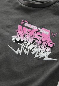 Mörkgrå bomullströja med en grafik av tre karaktärer i rosa och svart, med texten "HERO TRIO" och zickzackdetaljer.