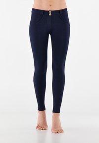 Leggings navy in materiale elasticizzato presentano una chiusura con due bottoni, tasche frontali e una vestibilità slim che si restringe alla caviglia.