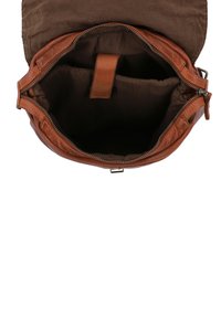Borsa in pelle marrone con un ampio interno aperto. Include una chiusura a zip frontale e una tasca interna. Texture morbida e forma arrotondata.