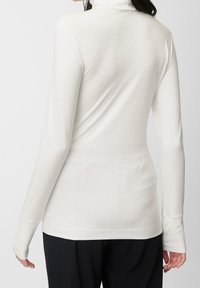 Witte lange mouwen turtleneck top gemaakt van zachte stof, met een slim fit en een gladde textuur. Inclusief duimopeningen bij de manchetten.