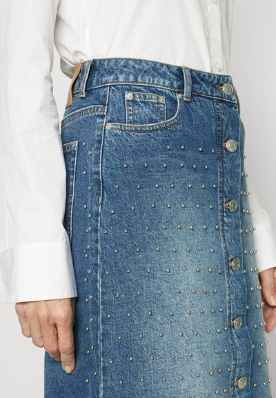 Jeansrock mit hoher Taille, verblasste blaue Farbe, verziert mit silbernen Nieten und Metallknopfverschlüssen an der Vorderseite.