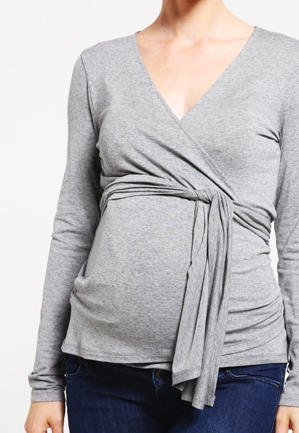 Gray long-sleeve top with a wrap design, featuring soft jersey fabric and a tied waist accent. Suitable for maternity wear.