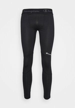 Leggings noirs en tissu extensible, dotés d'une large taille noire avec le logo "Champion" et d'un petit logo blanc sur la cuisse.