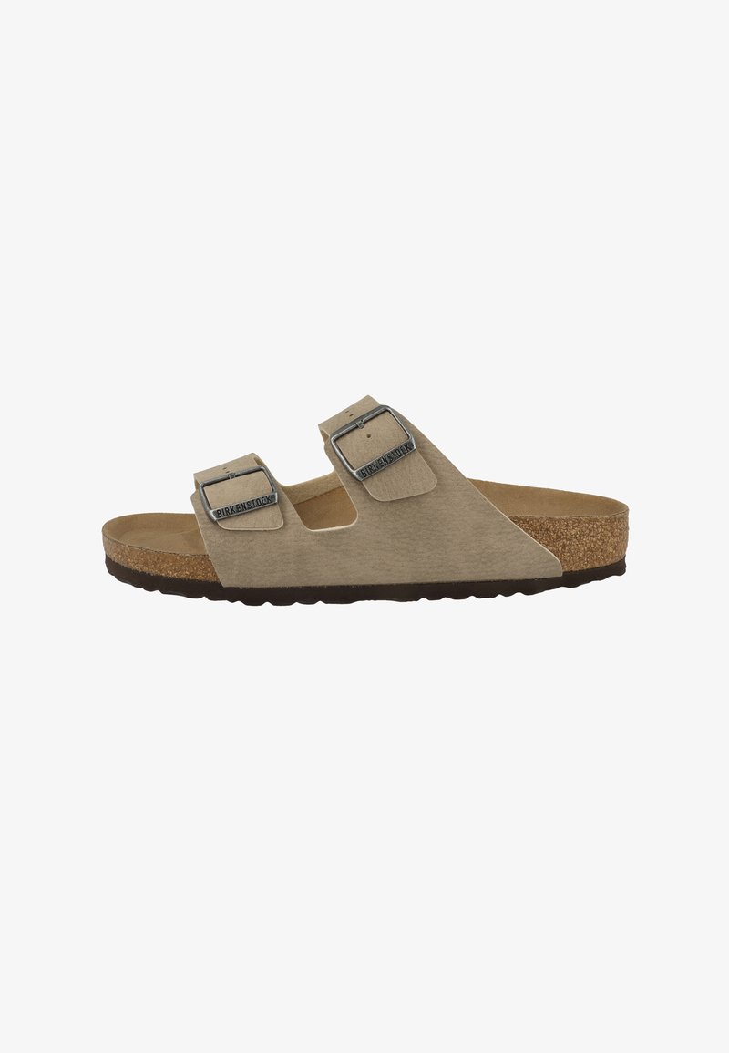 Beżowy sandał z odkrytymi palcami, wyposażony w dwa regulowane paski, metalowe klamry, korkową wkładkę oraz czarną gumową podeszwę.