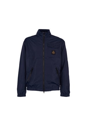 Veste bleu marine en matériau léger, avec un col montant, une fermeture éclair à l'avant, des poignets élastiques, une poche poitrine et deux poches latérales zippées.