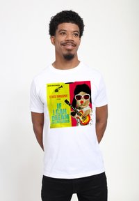Hvid bomulds t-shirt med et farverigt, vintage-inspireret grafisk design med en bjørn i solbriller, der spiller guitar, samt fed tekst.