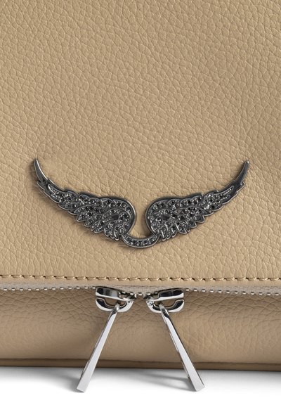 Μπεζ δερμάτινη τσάντα με υφή και ασημένιο έμβλημα φτερού επάνω από δύο ασημένια φερμουάρ.