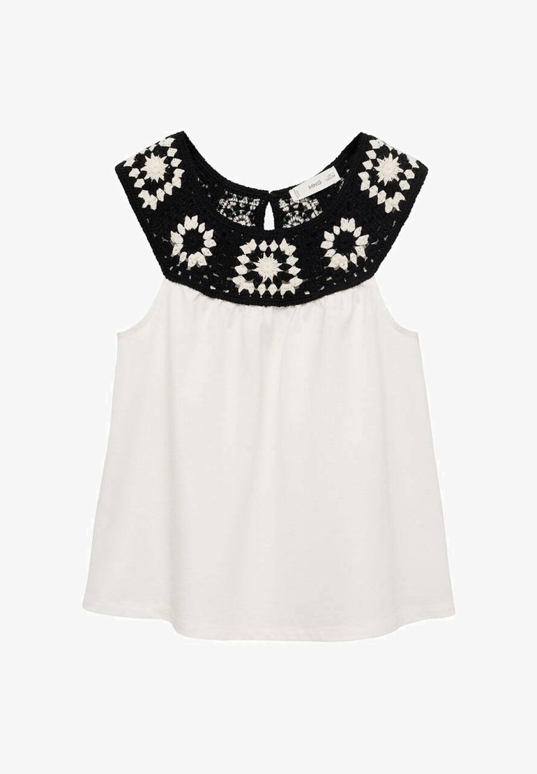 Bela brezrokavna majica z črno, kvačkasto cvetličnim vzorcem na ovratniku. Mehka tkanina z sproščenim krojem in nabranim pasom.