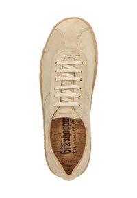 Baskets en suède beige avec une surface texturée, lacets plats beige et semelle en caoutchouc. L'intérieur présente une semelle en liège avec un texte de marque.