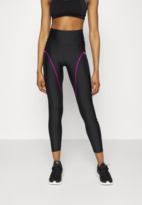 Svarta träningsleggings med rosa detaljer, hög midja, figurnära design och slät textur, kombinerat med svarta träningsskor.