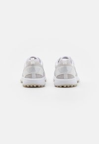 Vitaidiga sportskor med en texturerad mesh-överdela och mjuka läderpaneler. Har en dämpad sula och en dragflik vid hälen.