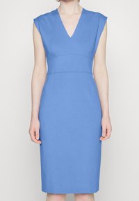 Niebieska sukienka bez rękawów z dekoltem w kształcie litery V, dopasowanym korpusem i prostą spódnicą. Gładki materiał i subtelne przeszycia akcentują smukłą sylwetkę.