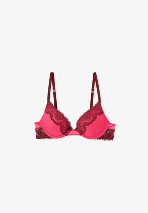 Pink lace-trimmed bra with burgundy detailing, featuring underwire, adjustable straps, and a textured fabric. Scalloped edges add detail.