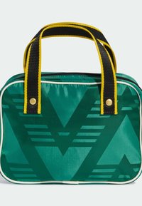Πράσινη τσάντα από νάιλον με έντονο γεωμετρικό σχέδιο σε σκουρότερο πράσινο. Διαθέτει κίτρινες και μαύρες λαβές και λευκή επένδυση φερμουάρ.