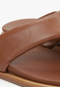 Bruine leren sandalen met een gladde, gestructureerde bandontwerp en een gevoerd voetbed. Kenmerkt een platte zool met een ronde vorm.