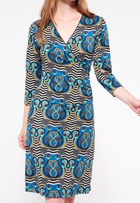 Wrap dress featuring a v-neckline, three-quarter sleeves, and a pattern of blue and gold swirls on a black and white striped background.