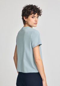 Kortärmad, ljusblå t-shirt i mjukt tyg. Har en rundad halsringning och en avslappnad passform, med en rak fåll och slät yta.