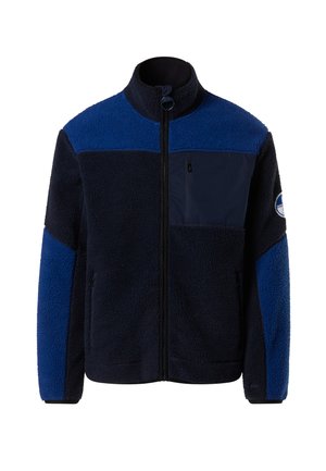 Giacca in pile blu navy e blu con cerniera frontale, collo alto, tasca sul petto e tessuto morbido. Presenta grandi pannelli blu sulle spalle e sulle braccia.