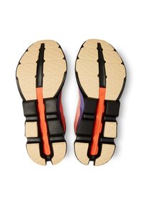 Sleek running shoe soles with a cream-colored tread, black accents, and a vibrant orange central strip. Textured surface for grip.