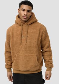 Brown fleece hoodie with a plush texture, drawstring hood, front pocket, and subtle logo embroidery. Ribbed cuffs and hem complete the design.