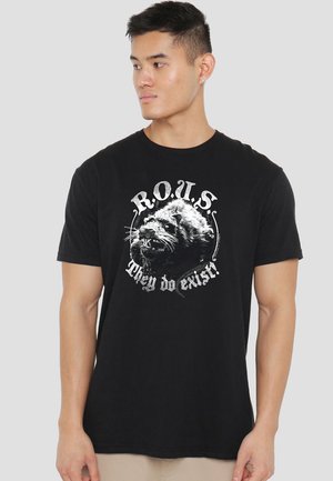 Black cotton t-shirt featuring a graphic of a rat's face and text reading "R.O.U.S. They do exist!" in white and gray tones.