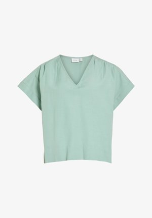 Blouse vert clair à manches courtes avec col en V, coupe ample et plis subtils aux épaules, fabriquée en tissu doux.