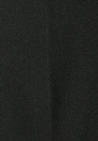 Tissu noir avec une surface douce et texturée, présentant un éclat subtil. Le matériau semble légèrement duveteux, indiquant chaleur et confort.