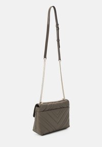 Sac bandoulière matelassé vert olive avec chaîne et bandoulière en cuir, présentant un motif géométrique et une fermeture à rabat. Texture lisse.