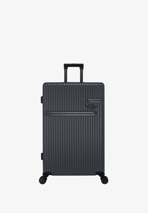 Harde koffer in donkergrijs met verticale ribbels, telescopische handgreep en vier wielen voor mobiliteit. Heeft een opvallend S-vormig ontwerp.