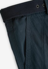 Dunkelblaue, leichte Stoffhosen mit einem strukturierten elastischen Bund und Details mit Metallösen. Verfügt über saubere Nähte entlang der Säume.