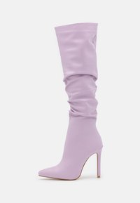 Bottes montantes lilas à bout pointu, en matière lisse, présentant un design ample et un talon haut à aiguilles.