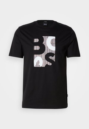 T-shirt en coton noir avec un grand motif en blanc et beige, comprenant des formes et les lettres "BOSS" dans un design rectangulaire.