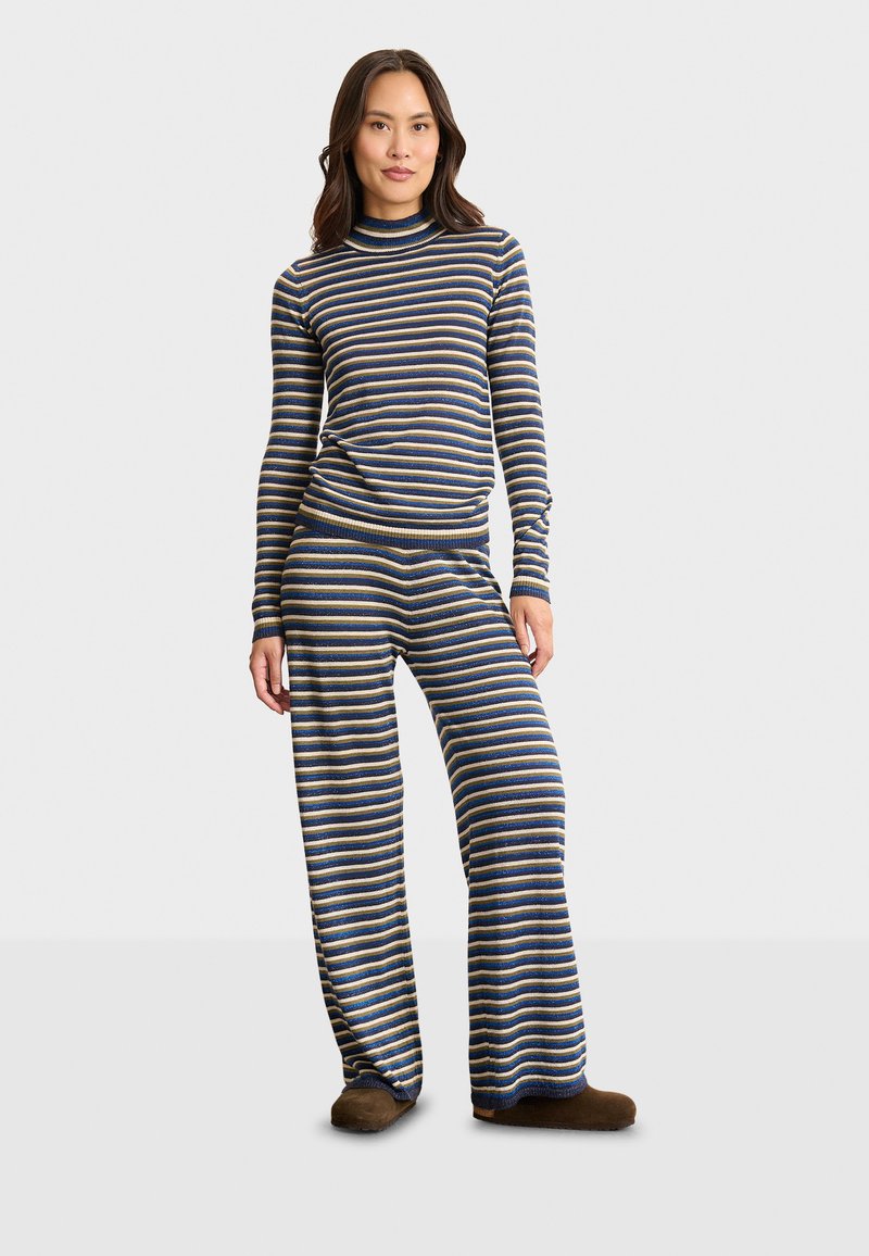 Gestreiftes Loungewear-Set mit einem Rollkragenoberteil und weit geschnittenen Hosen in Marineblau, Gold und Creme, hergestellt aus weichem, dehnbarem Stoff.