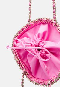 Pochette rose vif à cordon avec bandoulière chaîne torsadée dorée et rose, vue de dessus montrant la fermeture en tissu froncée.