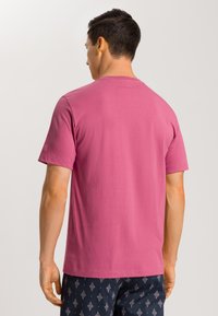 T-shirt da uomo a maniche corte in cotone rosa brillante. Design semplice con scollo rotondo e orlo dritto, abbinato a pantaloni corti fantasia.