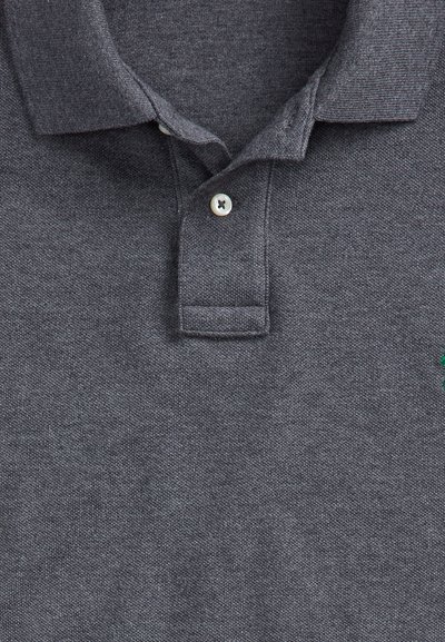 Polo gris foncé en tissu texturé, un bouton fermé et un col plié.