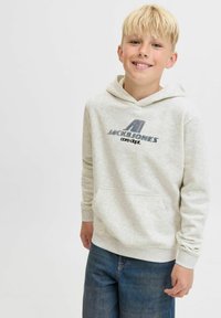 Hellgrauer Hoodie mit einer Vordertasche und Kordelzugkapuze, mit einem blauen Grafiklogo. Wird mit blauen Jeans getragen. Glatte Textur.