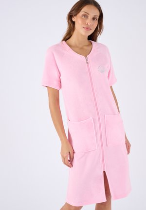 Bata rosa de manga corta fabricada en suave tela de rizo, con cremallera frontal, dos bolsillos delanteros y un emblema en forma de concha en el pecho.