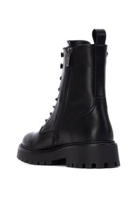 Stivali alla caviglia in pelle nera con punta rotonda, chiusura con lacci sul davanti, zip laterale e suola spessa e rigata. Fettuccia sul retro per una calzata facile.