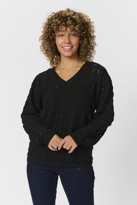 Maglione nero lavorato a maglia con scollo a V, caratterizzato da un motivo a onda testurizzato e polsini a costine, abbinato a jeans blu scuri.