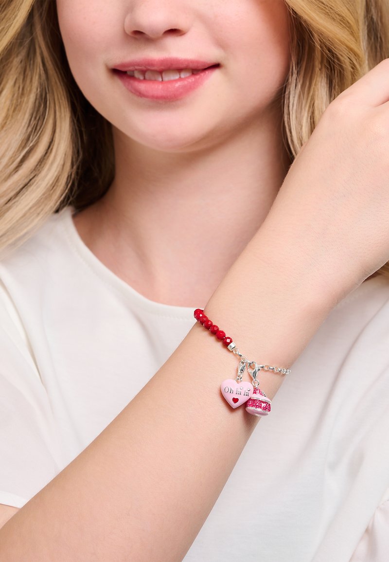 Bracelet de perles rouges avec chaîne en argent, orné d'un cœur rose et d'un charme étincelant, texte "Oh Hi" sur le cœur. Texture lisse et accents colorés.