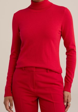 Red, long-sleeve turtleneck sweater made of soft knit fabric. Features a fitted design and ribbed cuffs, paired with matching red trousers.