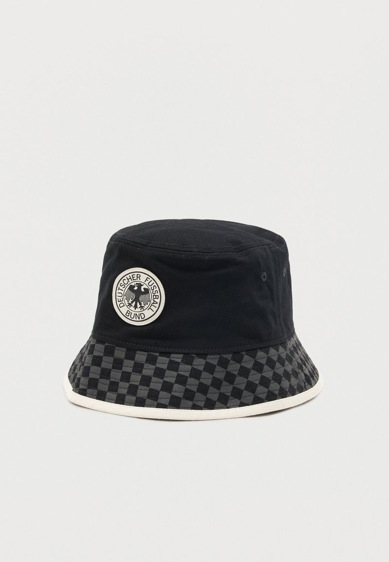 Μαύρο καπέλο τύπου κουβά με καρό γείσο και κυκλικό μπάλωμα που απεικονίζει το λογότυπο αετού της Γερμανικής Ποδοσφαιρικής Ομοσπονδίας.